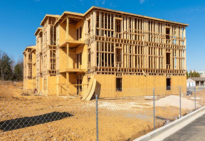 a temporary chain link fence winding around a construction site, outlining the project's progress in Owasso OK